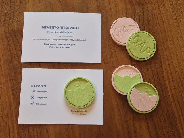 Two pairs of Gap Coins in pink and green — one pair embossed GAP, the other showing a two-tone landscape with a sun and an infinity symbol — beside the Memento Intervalli cards.