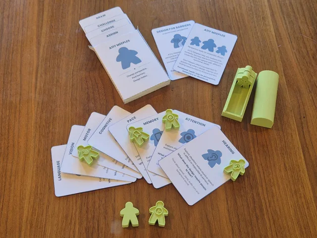 Pale green meeple figures, each embossed with a different symbol, standing on cards labelled Language, Vision, Motor, Cognitive, Pace, Memory, Attention and Hearing, beside the printed Gapplings deck.